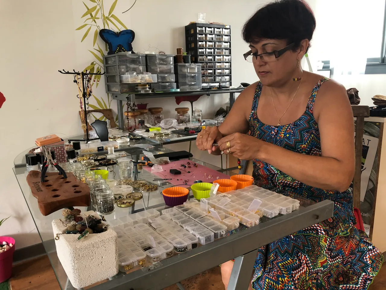 Guylaine Hoarau façonne une perle de cire d'abeille à son établi